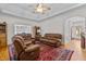 Cozy living room with wood floors, ceiling fan, and leather furniture, creating a warm and inviting atmosphere at 9 Piney Grove Rd, Bahama, NC 27503