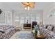 Bright living room featuring floral sofas, a decorative ceiling fan, and large windows at 9 Piney Grove Rd, Bahama, NC 27503