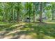 Expansive backyard with mature trees and a storage shed, offering privacy and natural beauty at 908 Snow Hill Rd, Durham, NC 27712