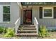 Home exterior featuring a red front door with white trim and a small porch with painted brick and siding at 908 Snow Hill Rd, Durham, NC 27712
