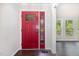 View of the red front door leading to a spacious living area with hardwood floors and natural light at 908 Snow Hill Rd, Durham, NC 27712