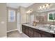 Bright bathroom features a double vanity with granite countertops and modern fixtures at 908 Woodland Grove Way, Wake Forest, NC 27587