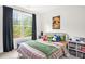 Colorful bedroom with a queen bed, a window with dark curtains, and decorative pillows and plush toys at 908 Woodland Grove Way, Wake Forest, NC 27587
