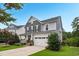 Charming two-story home with a well-maintained lawn, inviting front porch with stone details, and a convenient two-car garage at 908 Woodland Grove Way, Wake Forest, NC 27587