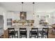 Bright kitchen featuring a large island with seating, modern appliances, and stylish pendant lighting at 908 Woodland Grove Way, Wake Forest, NC 27587