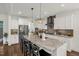 Spacious kitchen with gray backsplash, stainless appliances, island with barstool seating, and stone countertops at 908 Woodland Grove Way, Wake Forest, NC 27587