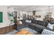 Open-concept living room with a large sectional sofa, and views of a modern kitchen with an island and bar seating at 908 Woodland Grove Way, Wake Forest, NC 27587