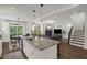 Open concept living with eat in kitchen, living room, and staircase with wood flooring and lots of natural light at 908 Woodland Grove Way, Wake Forest, NC 27587