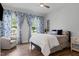 Cozy bedroom with patterned curtains, hardwood floors, and a comfortable bed with decorative pillows at 909 Green Oaks Pkwy, Holly Springs, NC 27540