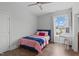 Bright bedroom with a single bed, ceiling fan, vanity desk, and wood-look flooring at 909 Green Oaks Pkwy, Holly Springs, NC 27540