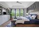 Inviting bedroom with tray ceiling, gray accent wall, blue bedding, sitting bench, and modern shelving at 909 Green Oaks Pkwy, Holly Springs, NC 27540