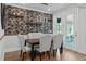 Dining room showcasing an accent wall, decorative wallpaper, upholstered chairs, and views to the exterior at 909 Green Oaks Pkwy, Holly Springs, NC 27540