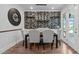 Beautiful dining area with a square table, upholstered chairs, decorative wallpaper, and French doors at 909 Green Oaks Pkwy, Holly Springs, NC 27540