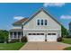 Back exterior of a two-story home featuring a three-car garage, and screened porch at 909 Green Oaks Pkwy, Holly Springs, NC 27540