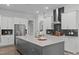 Gourmet kitchen with stainless steel appliances, an island, and a modern backsplash at 909 Green Oaks Pkwy, Holly Springs, NC 27540