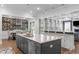 Gourmet kitchen with stainless steel appliances, gray island, and adjacent dining area at 909 Green Oaks Pkwy, Holly Springs, NC 27540