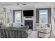 Living room featuring a fireplace, large windows, hardwood floors, and comfortable seating at 909 Green Oaks Pkwy, Holly Springs, NC 27540