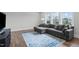 Spacious living room featuring a gray sectional sofa and a large area rug over hardwood floors at 909 Green Oaks Pkwy, Holly Springs, NC 27540