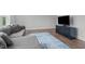 Comfortable living room with gray sectional sofa and entertainment center over hardwood floors at 909 Green Oaks Pkwy, Holly Springs, NC 27540