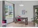 Bright office space with a wooden desk, comfortable chair, large window, and neutral decor at 909 Green Oaks Pkwy, Holly Springs, NC 27540