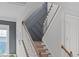 Well-lit stairway featuring carpeted steps, white railings, and modern gray accent wall at 909 Green Oaks Pkwy, Holly Springs, NC 27540