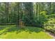 Lush backyard with a play set, lush greenery and mature trees providing a private wooded view at 102 Bosswood Ct, Cary, NC 27518