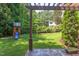 Beautiful backyard with a pergola and patio area, lush green grass, mature trees and playset at 102 Bosswood Ct, Cary, NC 27518