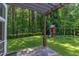Well-manicured backyard featuring lush grass, a play set, and a stone paver patio under a pergola at 102 Bosswood Ct, Cary, NC 27518