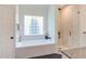 The bathroom features a soaking tub next to a glass shower with white marble tiling at 102 Bosswood Ct, Cary, NC 27518