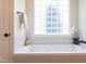 Bright bathroom featuring a soaking tub, tiled walls, and modern fixtures at 102 Bosswood Ct, Cary, NC 27518
