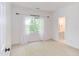 This bedroom is well-lit with neutral carpet and paint and has an attached bathroom at 102 Bosswood Ct, Cary, NC 27518