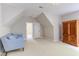 Spacious bonus room featuring a light blue couch and an armoire at 102 Bosswood Ct, Cary, NC 27518
