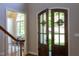 Inviting entryway features a wood staircase and double doors leading to a sunlit room at 102 Bosswood Ct, Cary, NC 27518