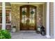 Elegant stone exterior with a beautiful double front door, complemented by stylish potted plants at 102 Bosswood Ct, Cary, NC 27518