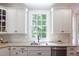 This kitchen features white cabinetry, granite countertops, stainless steel appliances and tiled backsplash at 102 Bosswood Ct, Cary, NC 27518