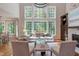 Bright living room with large windows, stone fireplace, hardwood floors and elegant chandelier at 102 Bosswood Ct, Cary, NC 27518