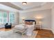 Spacious main bedroom with sitting area, large windows, hardwood floors, and tray ceiling at 102 Bosswood Ct, Cary, NC 27518