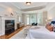 Well-lit main bedroom with hardwood floors, a fireplace, and access to outdoor space at 102 Bosswood Ct, Cary, NC 27518