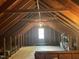 Attic space with exposed rafters and a small window offering natural light at 104 Belle Isle Ct, Cary, NC 27513