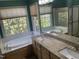 Relaxing bathroom featuring a large soaking tub, granite countertops, and an expansive window at 104 Belle Isle Ct, Cary, NC 27513