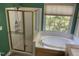 Bright bathroom featuring a shower, soaking tub, and window looking into the backyard at 104 Belle Isle Ct, Cary, NC 27513