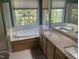 Relaxing bathroom featuring a large soaking tub, granite countertops, and an expansive window at 104 Belle Isle Ct, Cary, NC 27513
