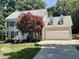 Charming two-story home with a well-manicured lawn, mature trees, and a two-car garage at 104 Belle Isle Ct, Cary, NC 27513