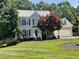 Charming two-story home with a well-manicured lawn and mature trees providing shade at 104 Belle Isle Ct, Cary, NC 27513