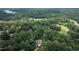 Vast aerial view revealing the home's location near a golf course, and lake, nestled in a dense forest at 105 Woodsage Way, Cary, NC 27518