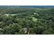 Expansive aerial view of property showcasing the home's location amidst a dense forest and nearby golf course at 105 Woodsage Way, Cary, NC 27518