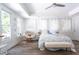 Inviting bedroom featuring a large window, wood-look flooring, a comfortable bed, and soft lighting at 105 Woodsage Way, Cary, NC 27518
