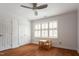 Bright bedroom with hardwood floors, neutral paint, shutters, a ceiling fan, and table at 105 Woodsage Way, Cary, NC 27518