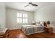 Cozy bedroom features hardwood floors, a window with shutters, and a comfortable bed at 105 Woodsage Way, Cary, NC 27518