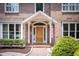 Inviting entryway with brick flooring, a solid wood door, sidelights, and neatly trimmed bushes at 105 Woodsage Way, Cary, NC 27518